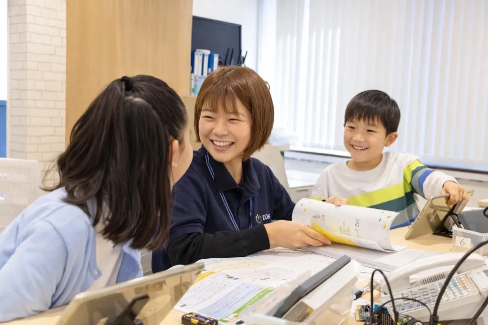 リアルワールド志向 - メンターと子どもたちが対面で電子部品やタブレットを使って学ぶ様子